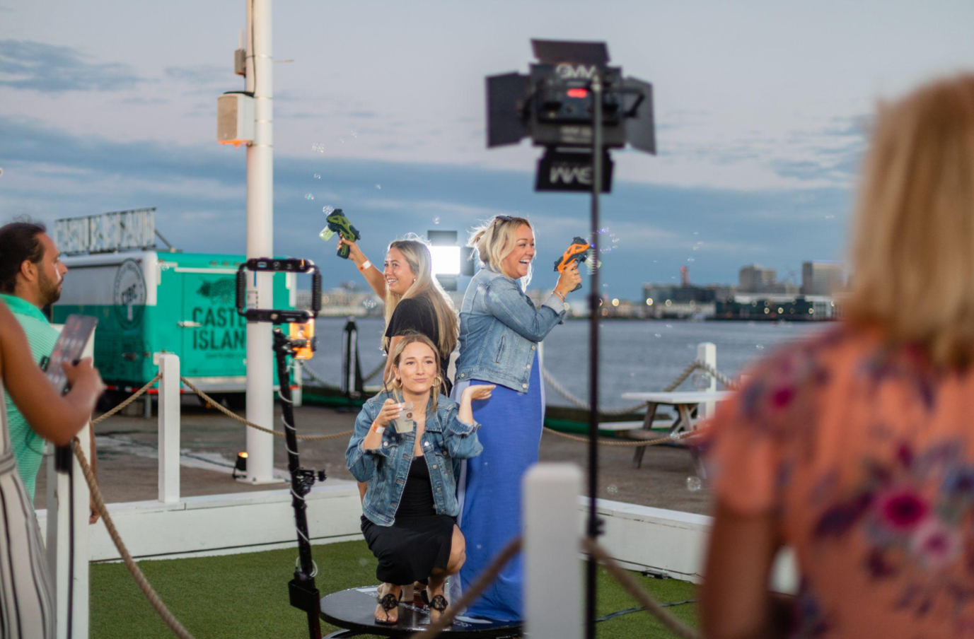 Guests using 360-degree photo booth at waterfront event on Cape Cod